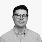 A man with short dark hair and round glasses smiles confidently, representing a professional face of Birdie's digital.