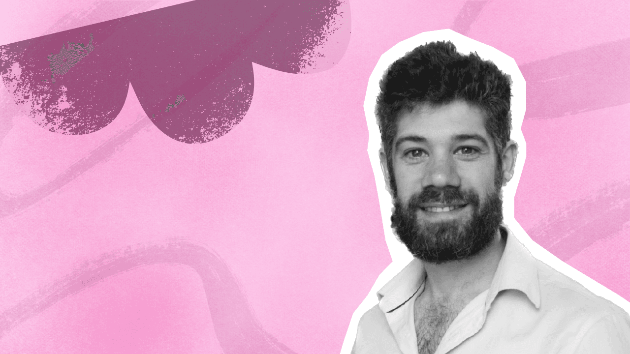 A smiling man with a beard, in black and white, against a vibrant pink and purple abstract background reflecting Birdie's.