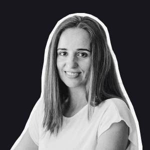 A smiling Birdie team member with long hair, wearing a white t-shirt, against a dark background representing Support Labs.