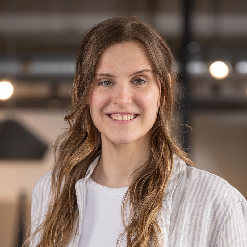Smiling woman with long brown hair wearing a striped shirt