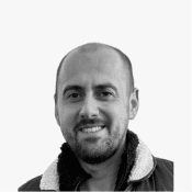 A smiling man with a beard and short hair, wearing a jacket with a fluffy collar, embodies the friendly Birdie team spirit.