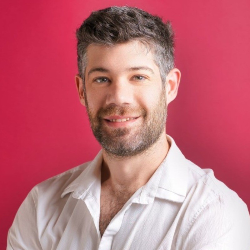 Smiling man with a beard wearing a white shirt